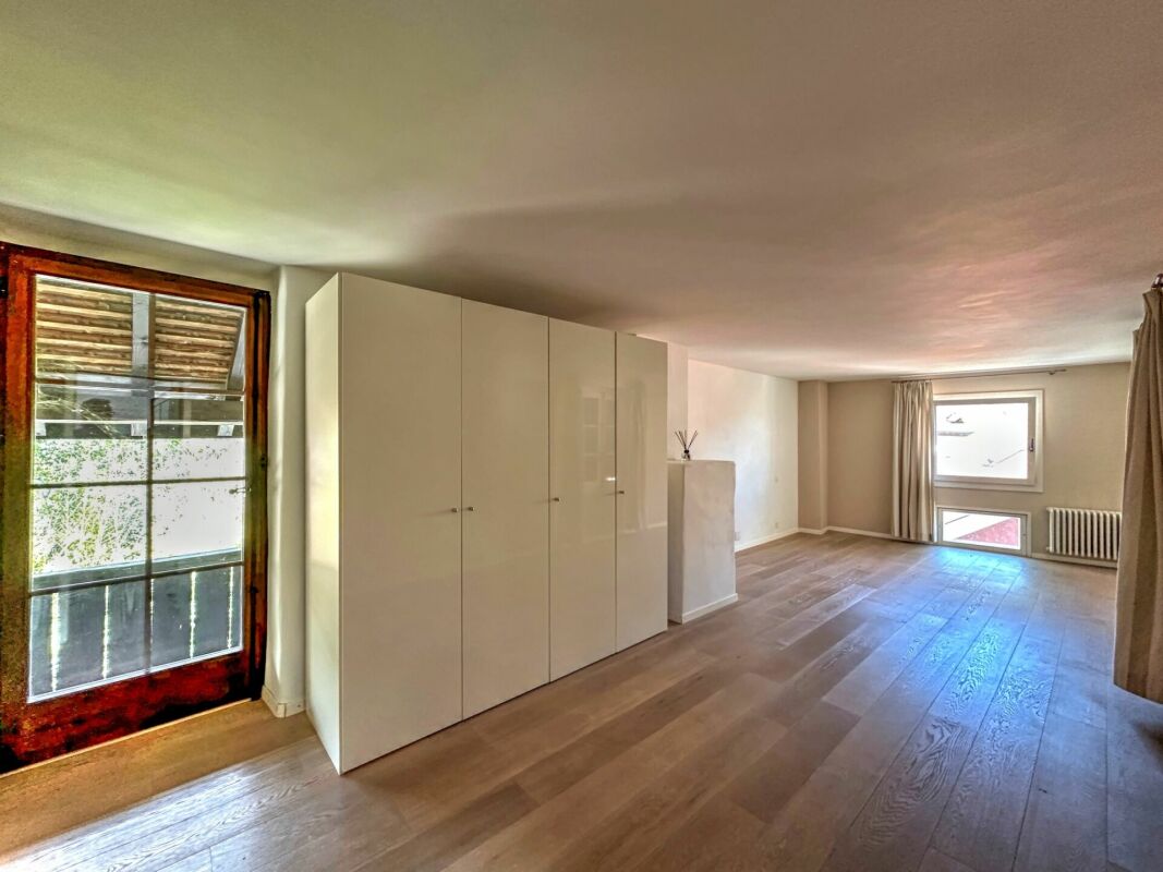 Heller leerer Wohnraum mit Holzfußboden und Einbauschrank