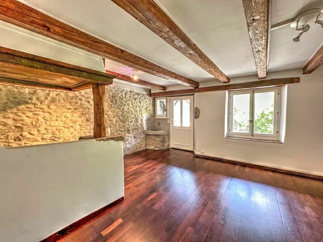 Rustikaler Wohnraum mit Holzbalken und Natursteinwand