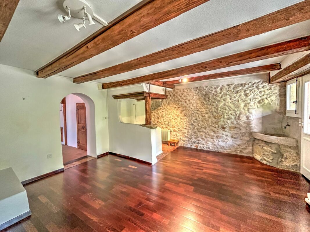 Wohnraum mit Natursteinwand und Holzbalkendecke