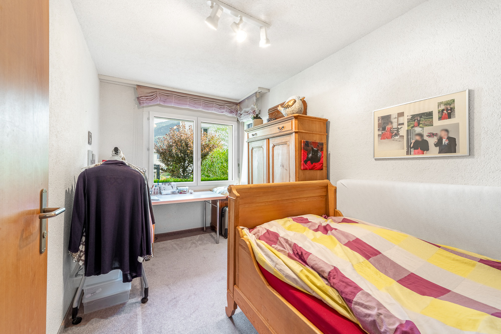 Kleines Schlafzimmer mit Schreibtisch am Fenster