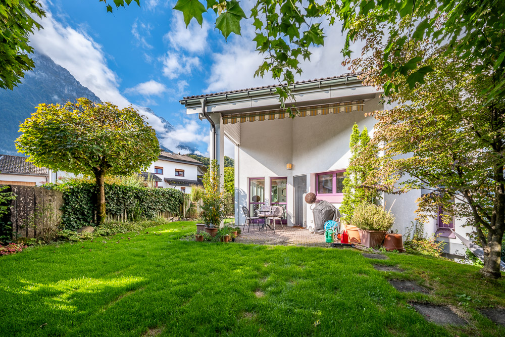 Gartenansicht eines Einfamilienhauses mit Terrasse