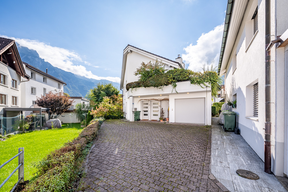 Außenansicht eines Wohnhauses mit Einfahrt und Garten