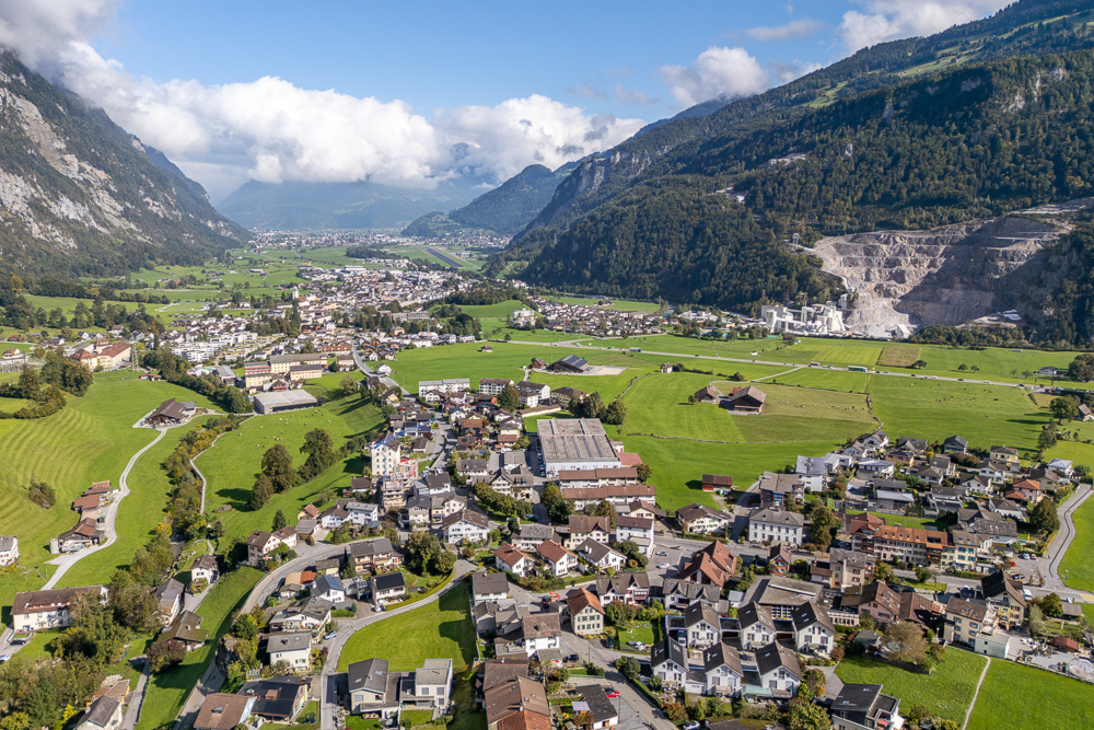 Luftaufnahme eines Alpentals mit Ortschaft