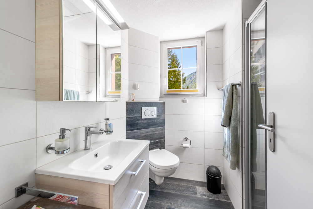 Helles, modernes Gäste-WC mit Fenster und Holzwaschtisch