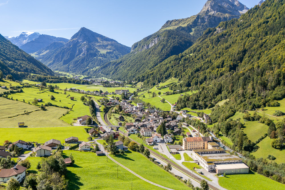 Luftaufnahme eines alpinen Tals mit Ortschaft