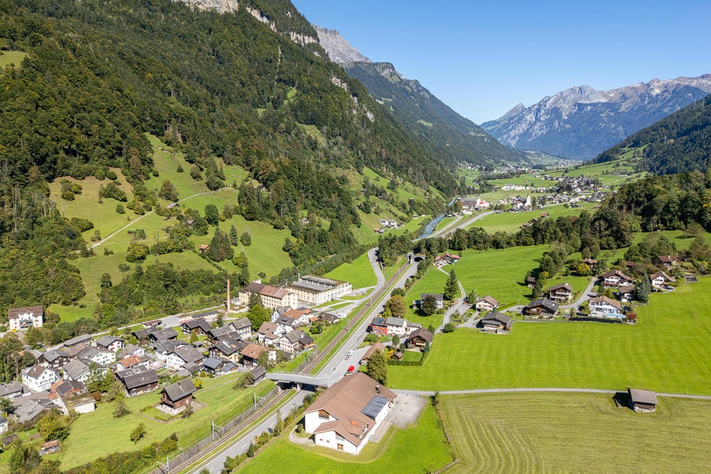 Alpenlandschaft mit Tal, Dorf und Bergen