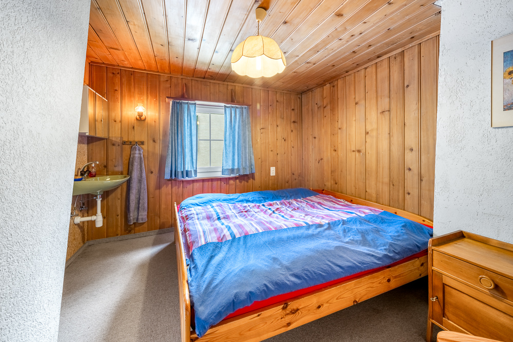 Rustikales Schlafzimmer mit Holzverkleidung