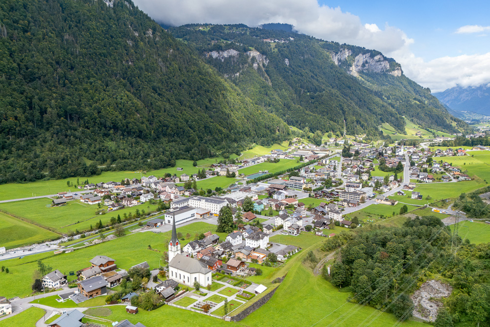 Luftaufnahme eines Alpentals mit Siedlung