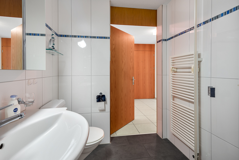 Badezimmer mit Fliesen und Holztür