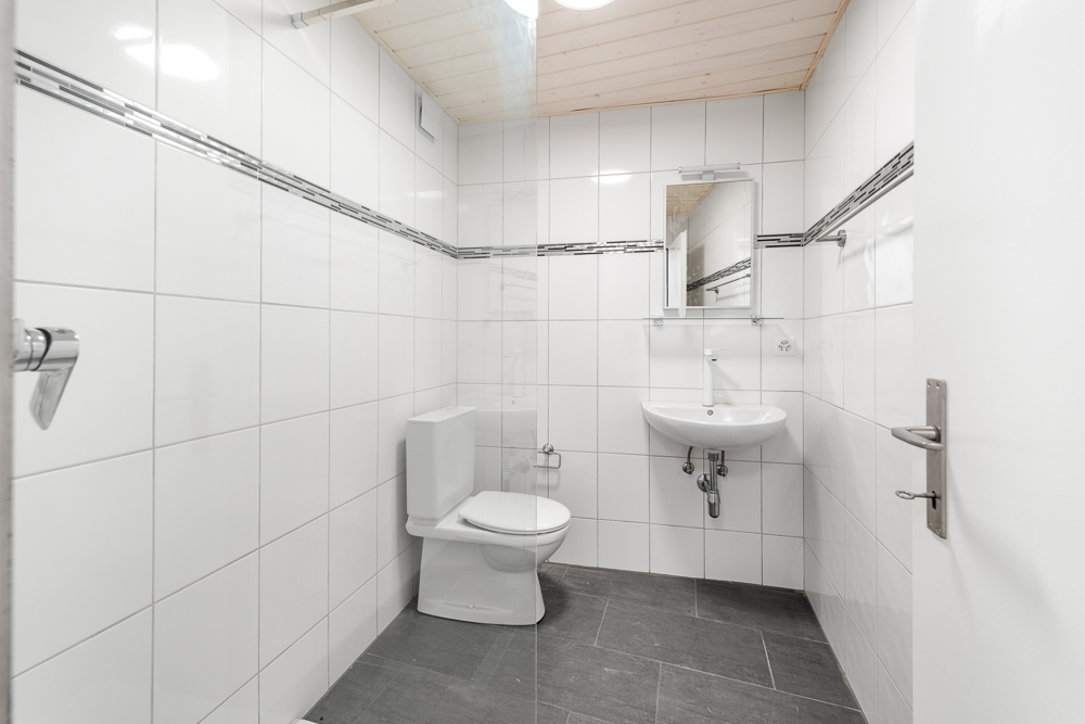 Kleines Gäste-WC mit weißen Wandfliesen