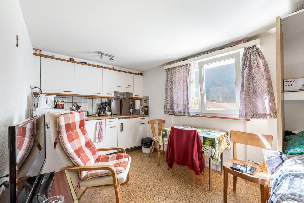 Kleine Wohnküche mit Fenster und Sitzbereich