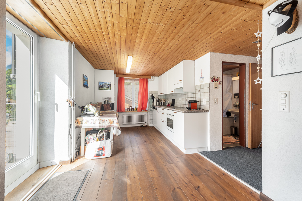 Heller Wohnungsflur mit Küche und Zugang zum Bad