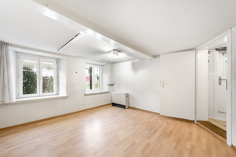 Heller leerer Wohnraum mit Fenstern und Türbereich