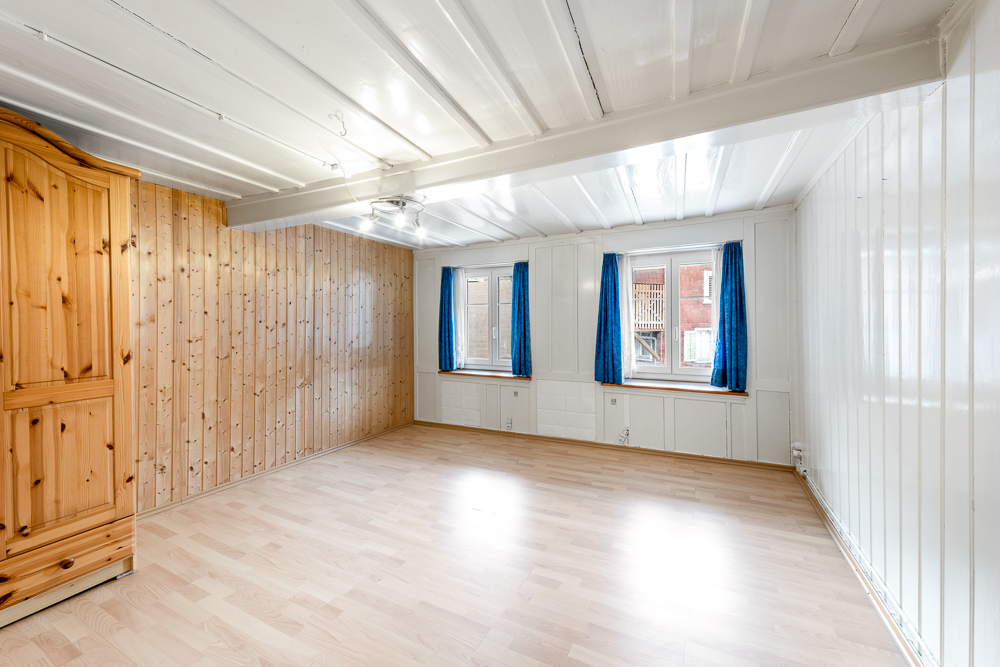 Helles, leeres Zimmer mit Holz- und Paneelwänden