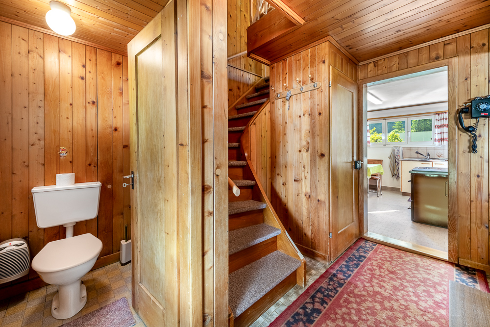 Holzvertäfelter Flur mit Treppe und Gäste-WC