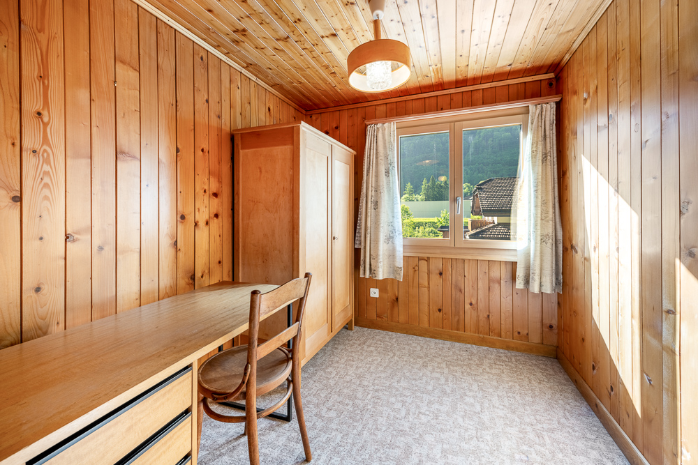 Holzvertägelter Raum mit Fenster und Schreibtisch