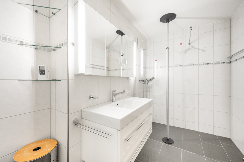 Helles, modernes Badezimmer mit Dusche und Waschtisch