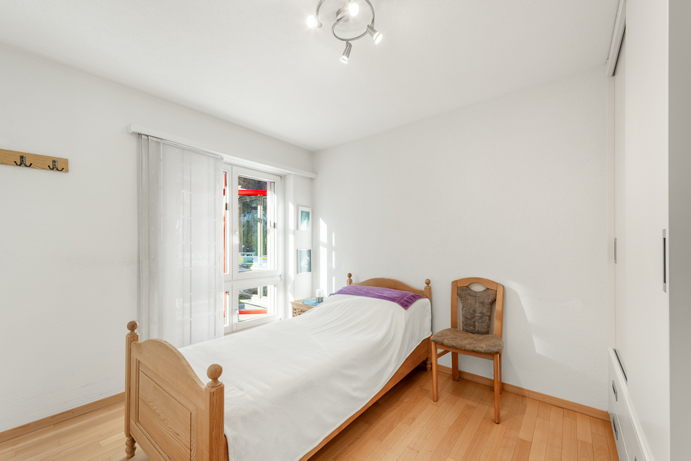Helles Einzelzimmer mit schlichtem Bett