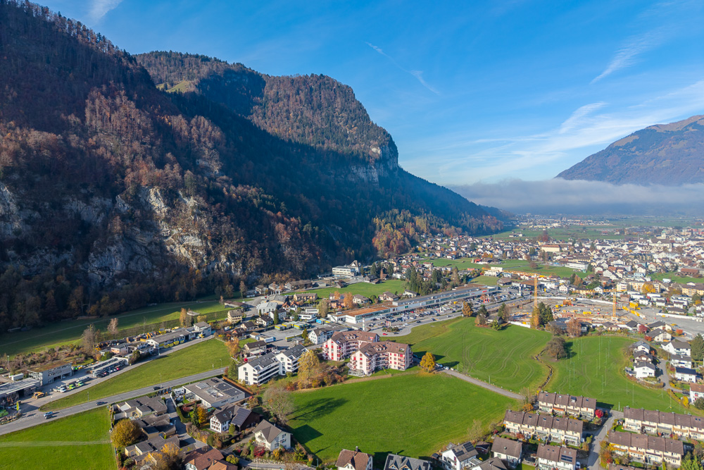 Luftaufnahme eines Tals mit Stadt und Bergen