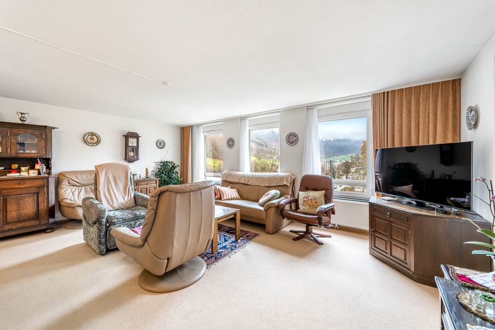 Wohnzimmer mit Panoramafenstern und Blick ins Grüne