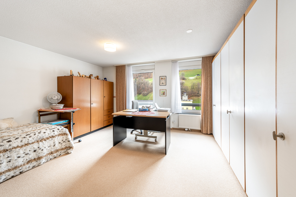 Helles Schlafzimmer mit Schrankwand und Schreibtisch
