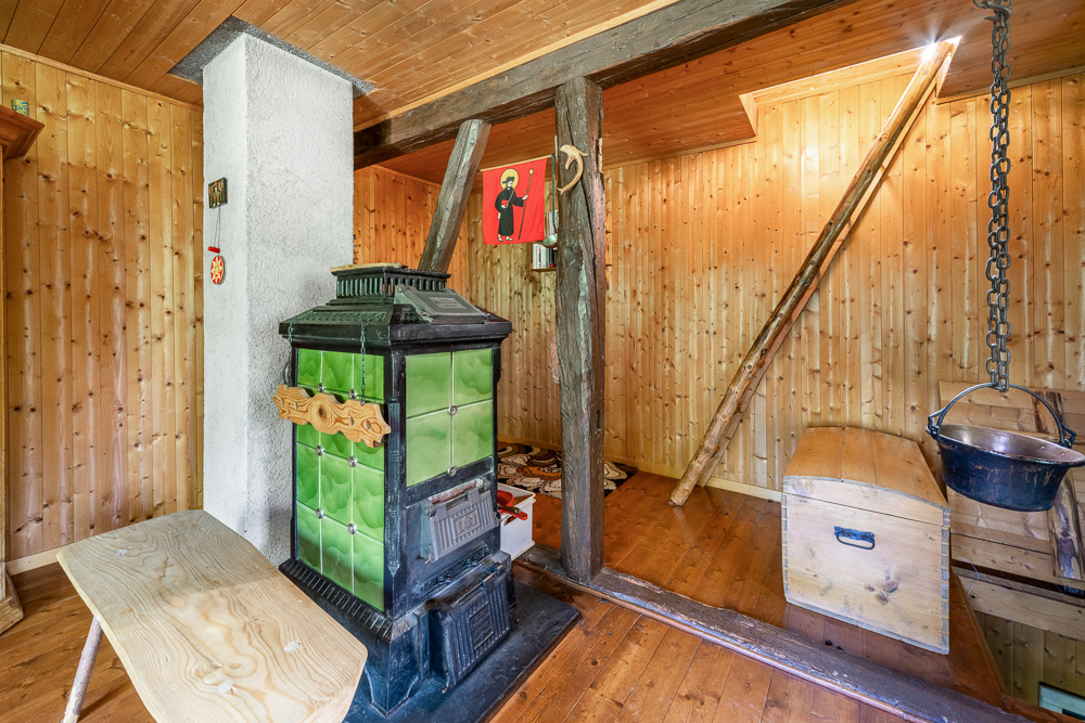 Rustikaler Raum mit Holzvertäfelung und Ofen