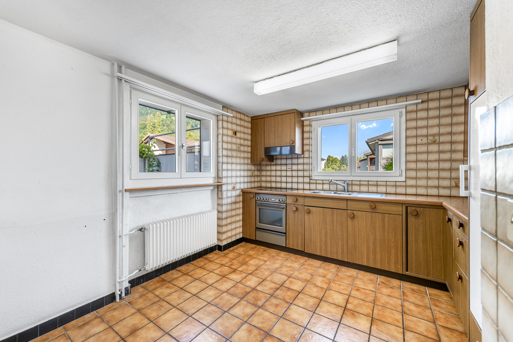 Kleine Küche mit Fliesenboden und Holzfronten