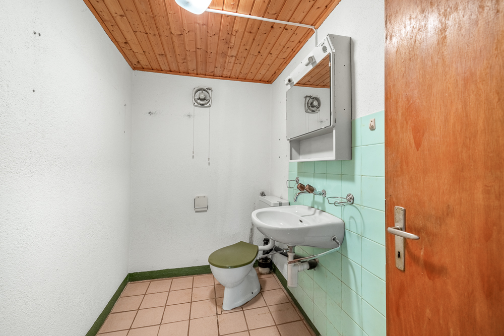 Kleines WC mit Holzdecke und mintgrünen Fliesen