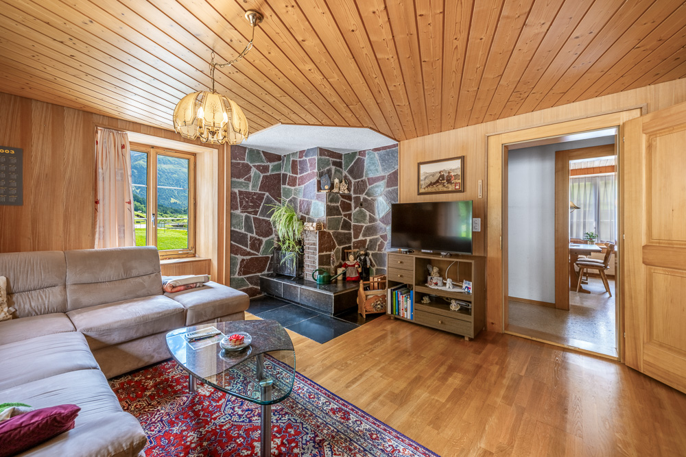 Gemütliches Wohnzimmer mit Holzvertäfelung und Steinkamin
