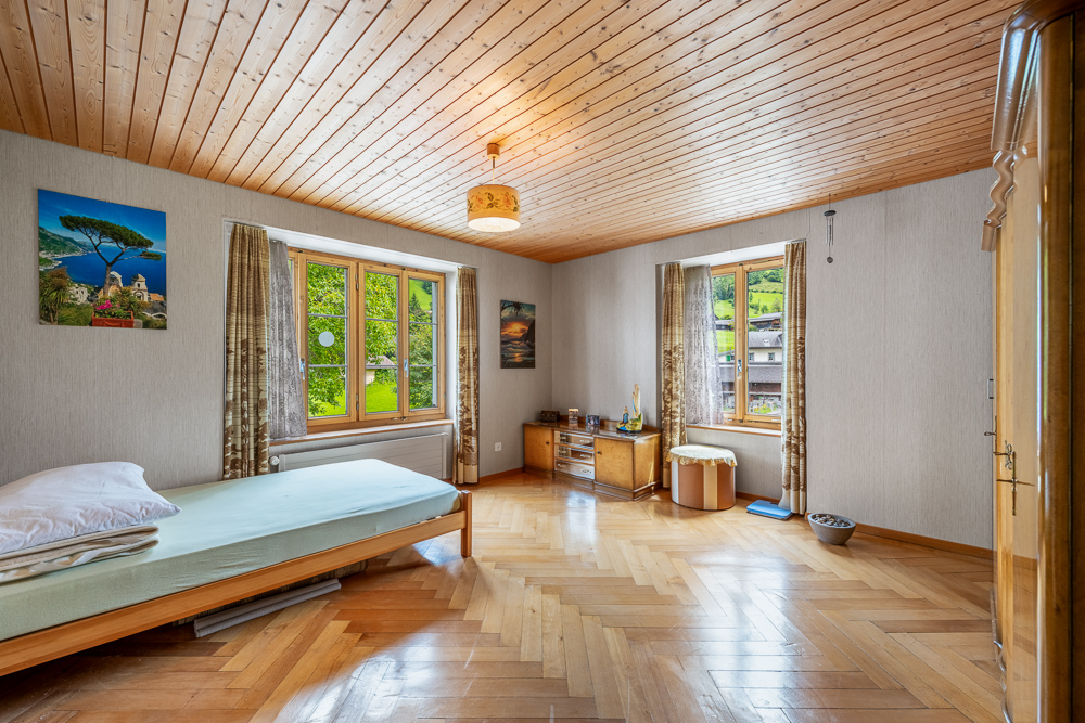 Helles Schlafzimmer mit Holzdecke und Parkett