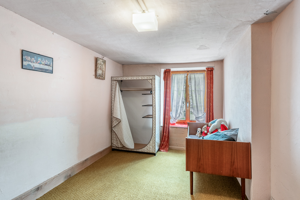 Schmales Schlafzimmer mit einfachem Mobiliar