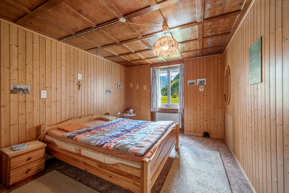 Rustikales Schlafzimmer mit Holzverkleidung
