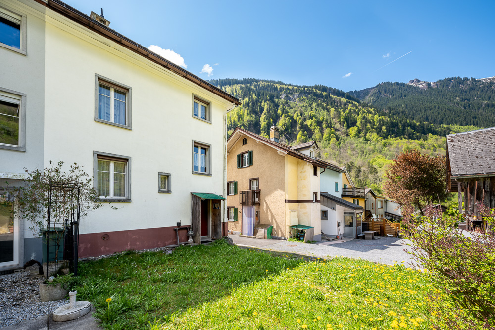 Wohnhäuser mit Garten und Bergkulisse