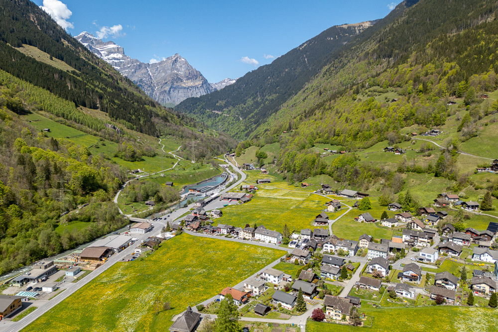 Alpental mit Siedlung und Bergkulisse