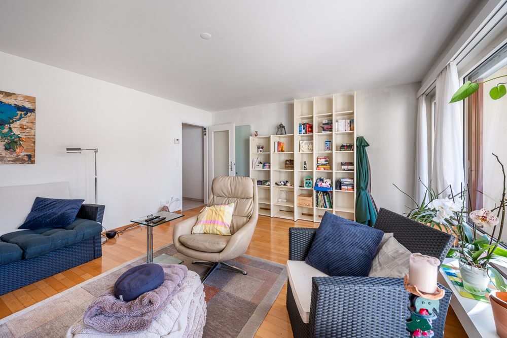 Helles Wohnzimmer mit Sitzgruppe und Bücherregal