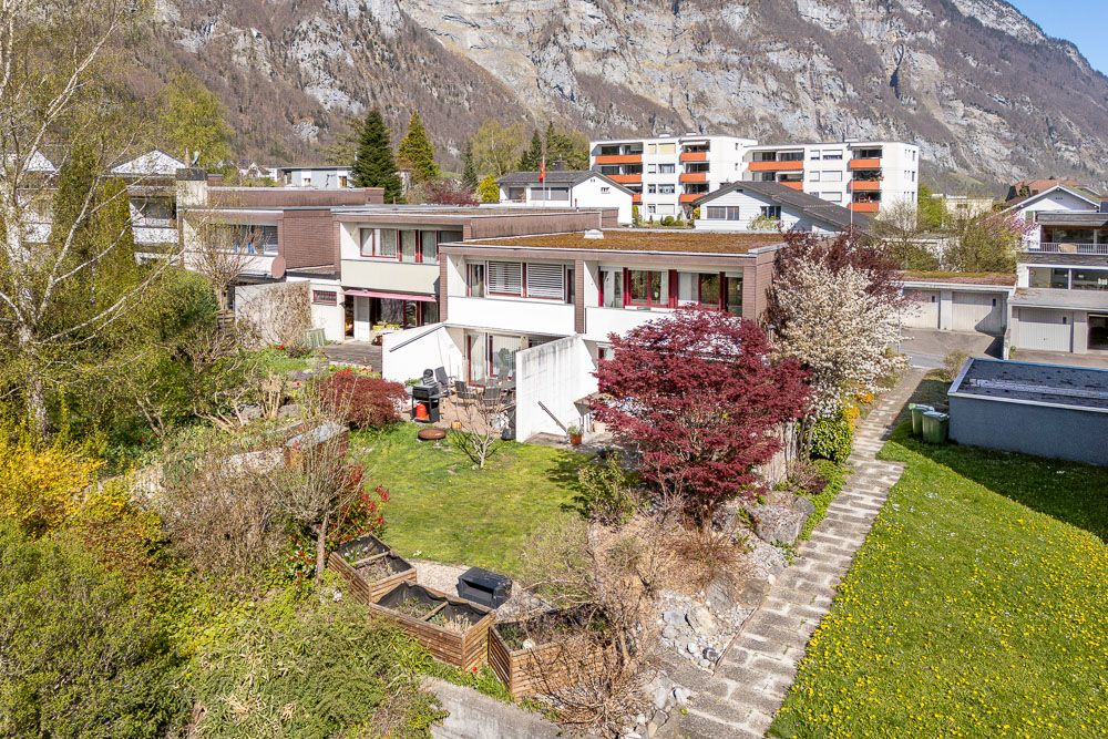 Außenansicht eines Wohnhauses mit Garten und Bergkulisse