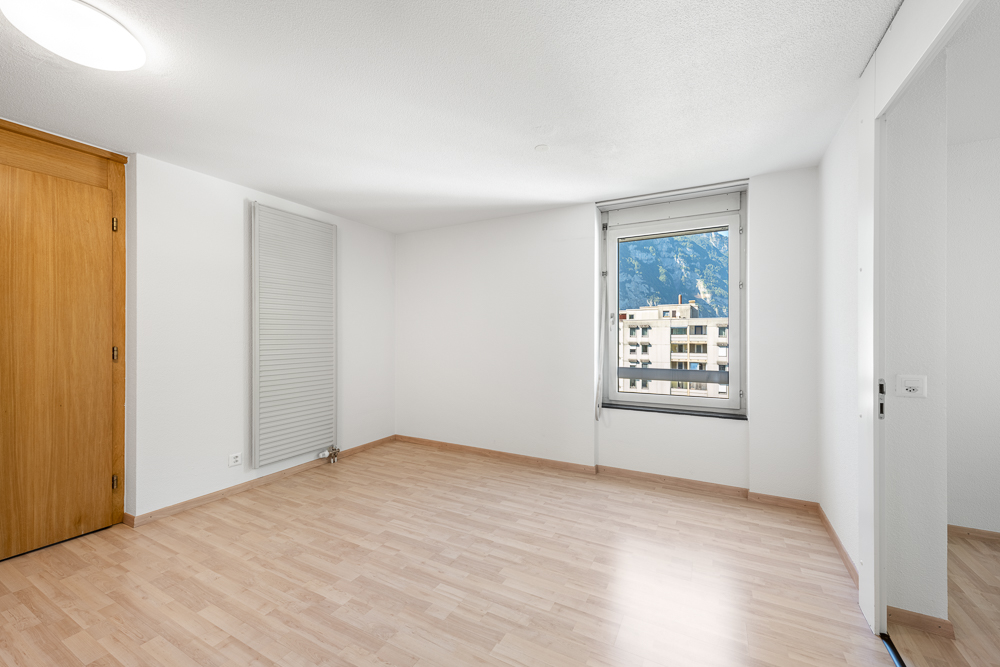 Heller leerer Raum mit Fenster und Holztür