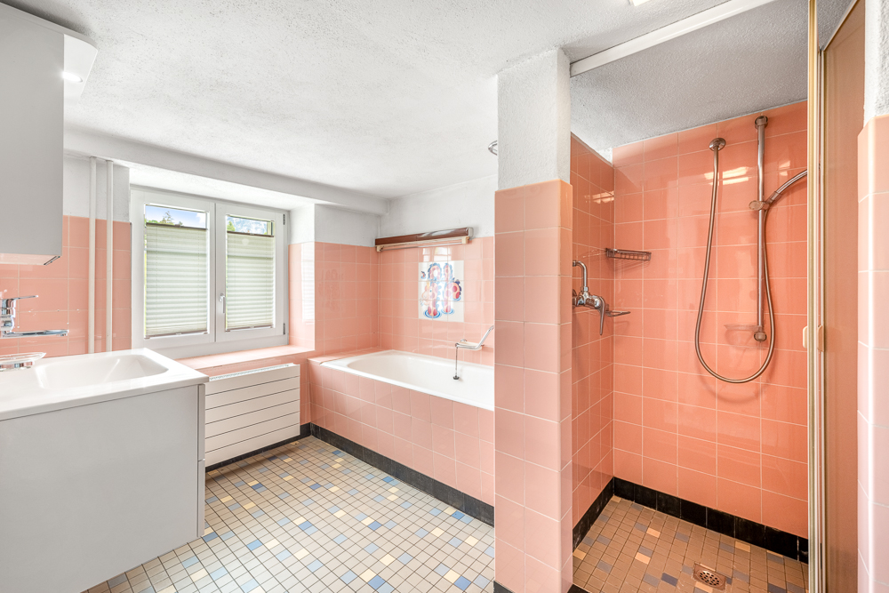 Badezimmer mit rosa Fliesen und Badewanne