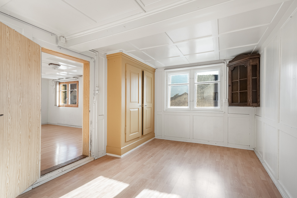 Heller Innenraum mit Fenster, Einbauschrank und Holztüröffnung