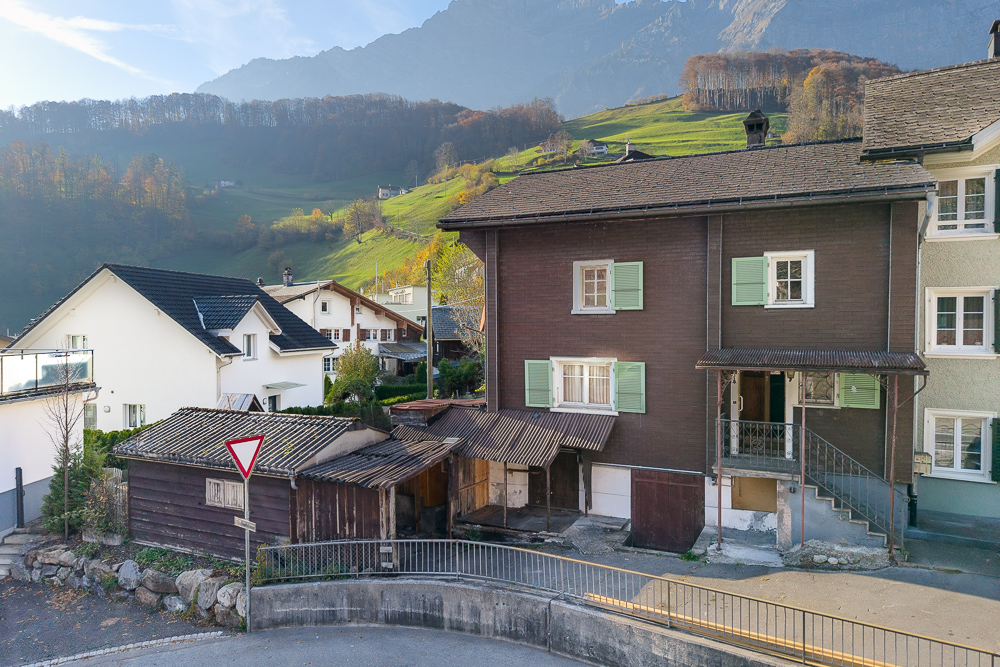 Bergdorf mit Wohnhäusern und alpiner Kulisse