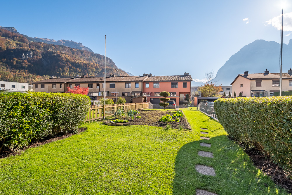 Garten mit Bergkulisse und Reihenhäusern