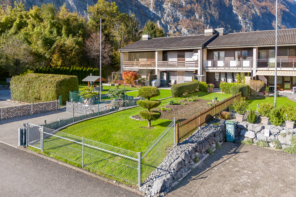 Wohnanlage mit gepflegtem Garten und Bergkulisse