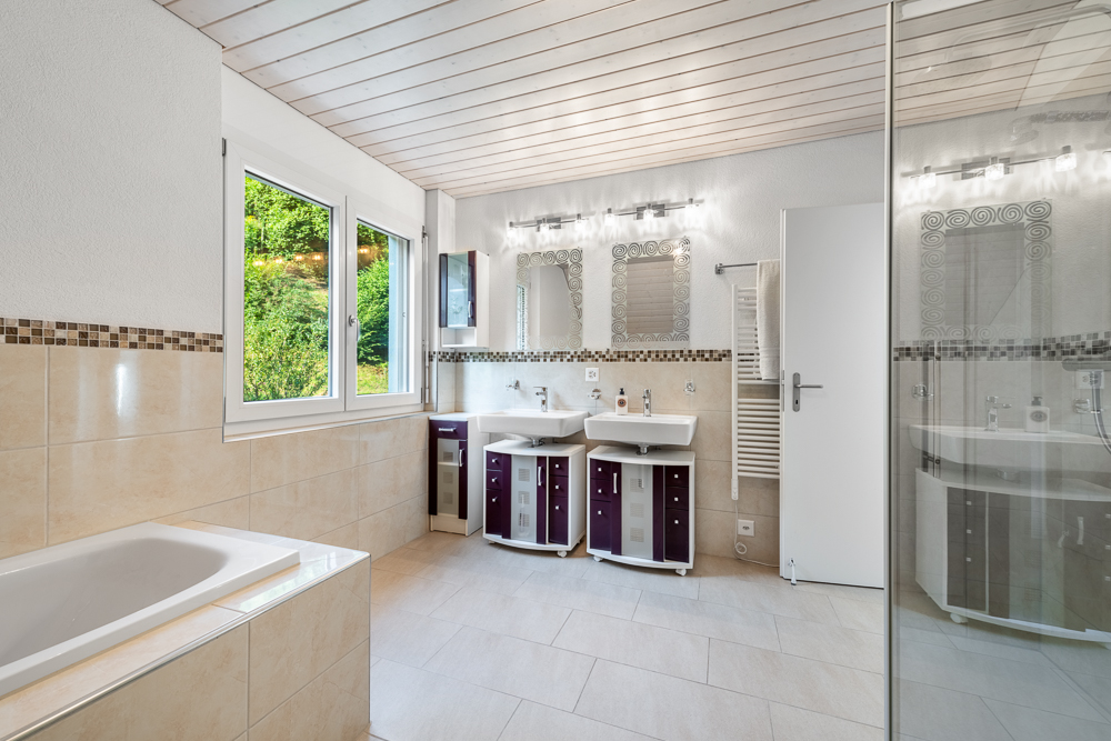 Modernes Badezimmer mit Badewanne, Doppelwaschtisch und Glasdusche