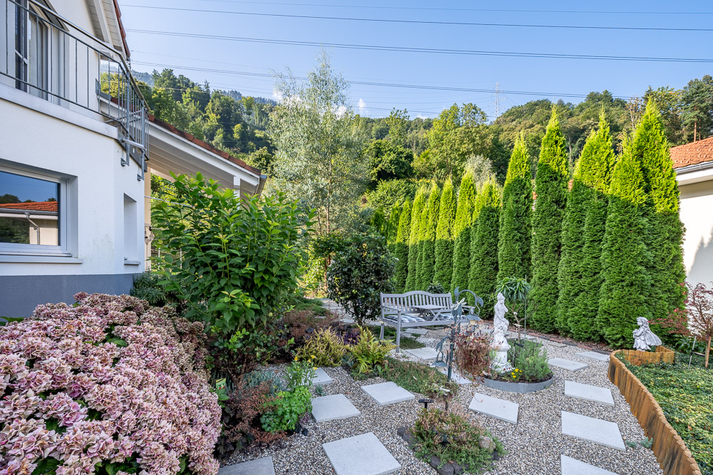 Gepflegter Garten mit Sitzbank und Zierpflanzen