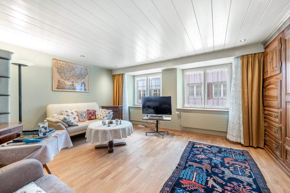 Wohnzimmer mit Holzvertäfelung und großen Fenstern