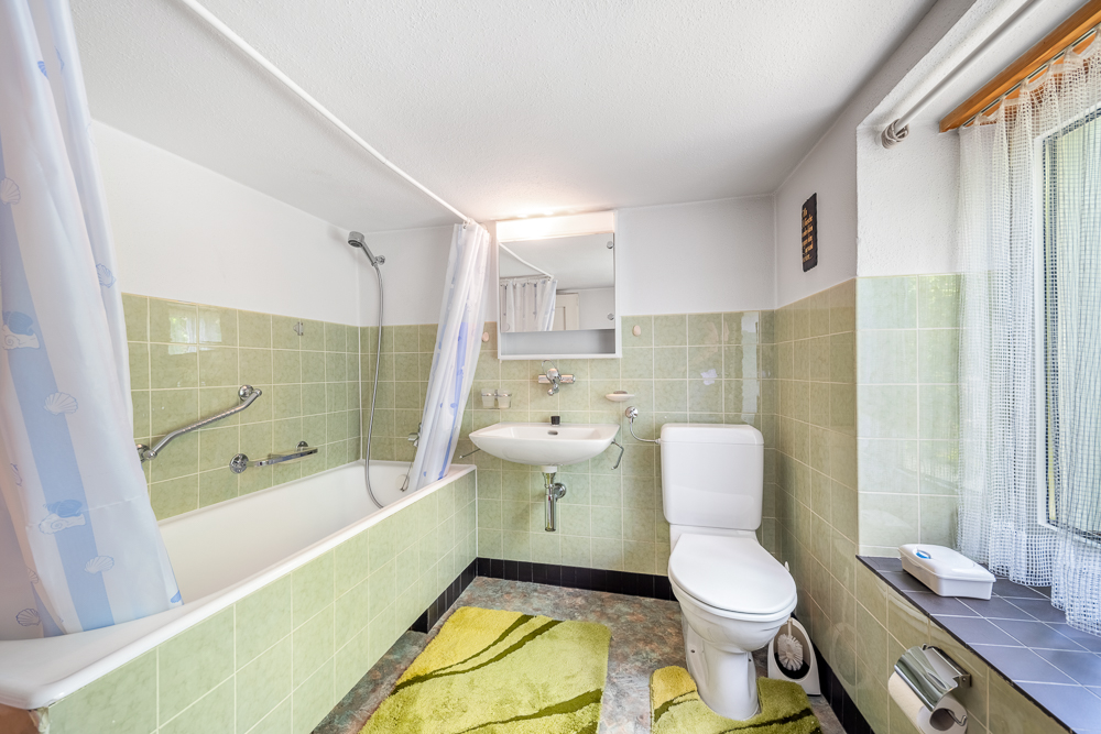 Helles, kompaktes Badezimmer mit Badewanne, Waschbecken und WC