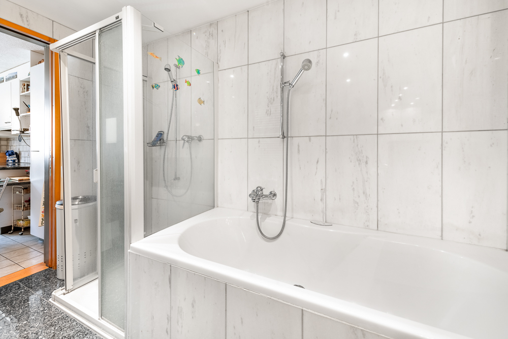 Badezimmer mit Badewanne und Duschabtrennung