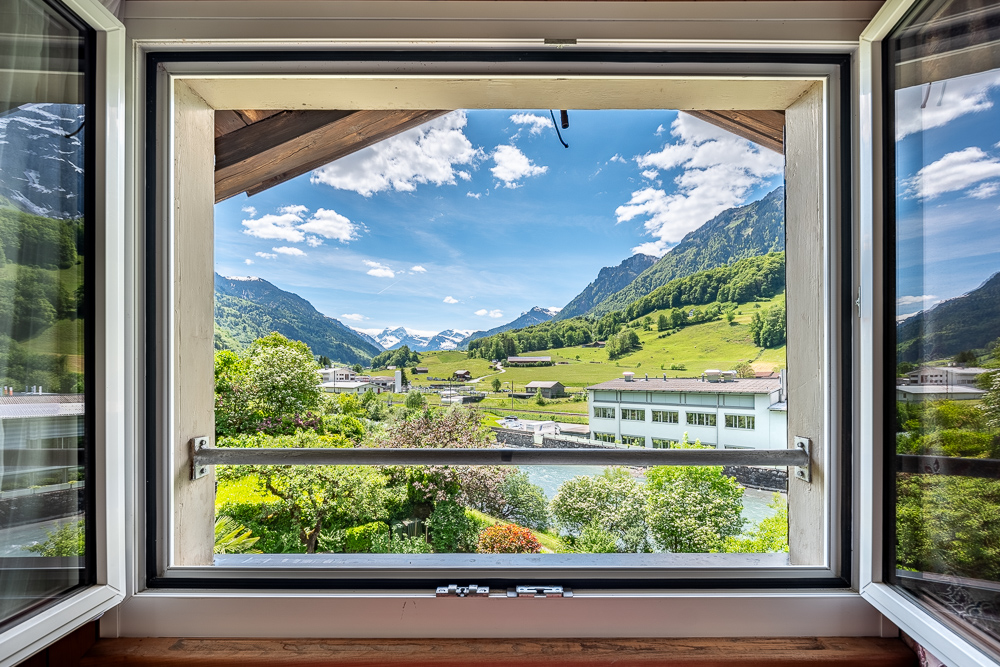 Bergblick durch ein geöffnetes Fenster