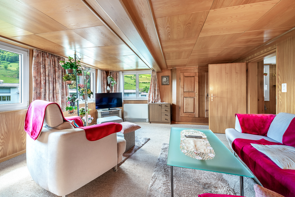 Wohnzimmer mit Holzverkleidung und Panoramafenstern