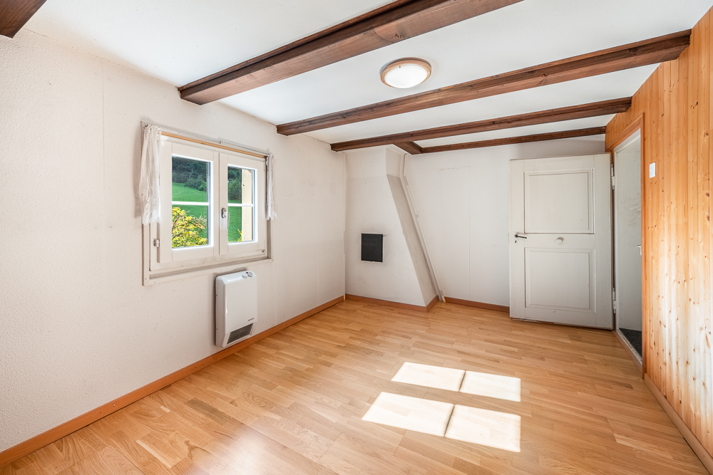 Kleines Zimmer mit Holzdecke und Fenster